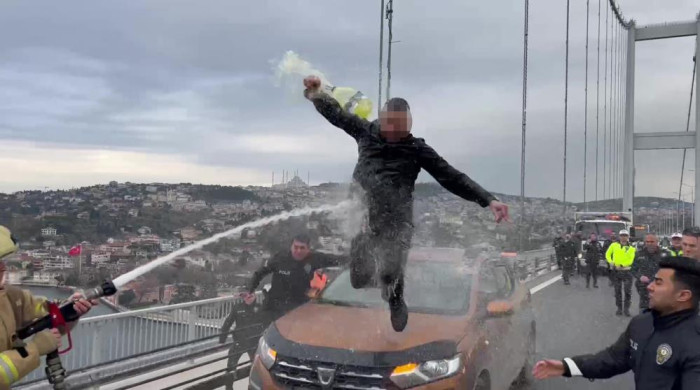 Otomobilin üzerine çıkıp benzin döken şahsa itfaiyeciden ‘su sıkma’ müdahalesi