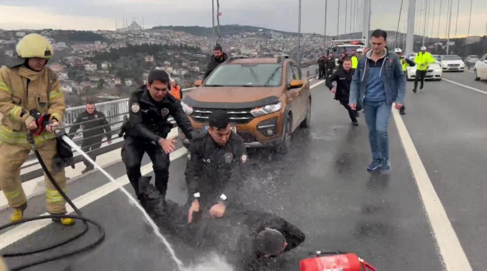Otomobilin üzerine çıkıp benzin döken şahsa itfaiyeciden ‘su sıkma’ müdahalesi